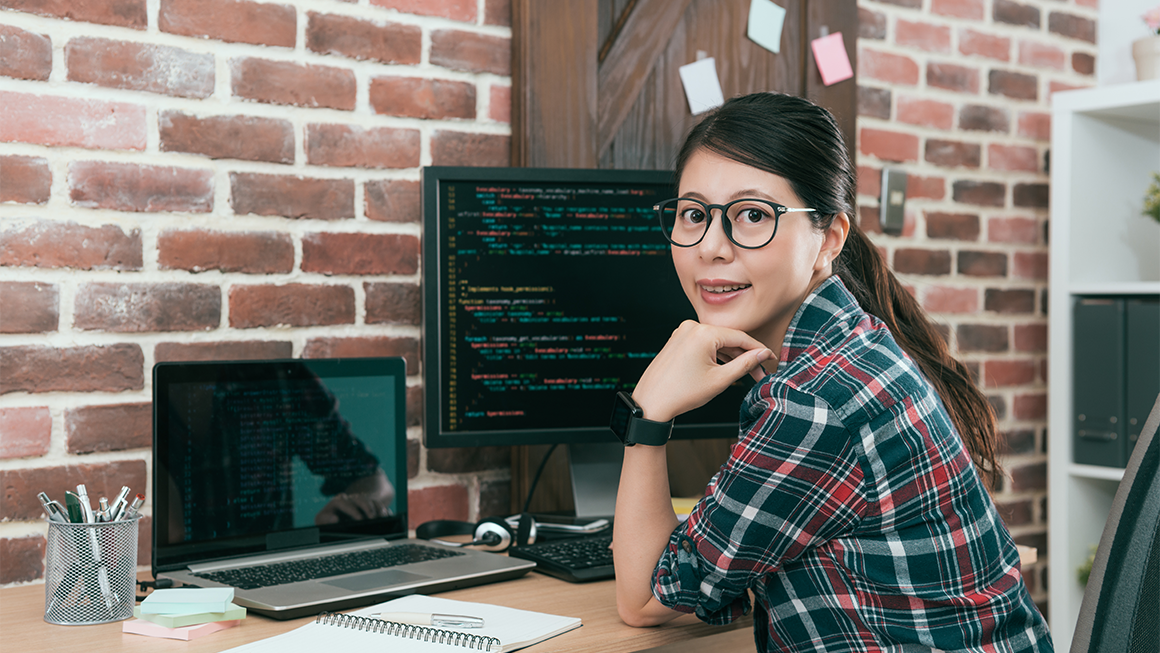 Woman with glasses sitting in front of a computer