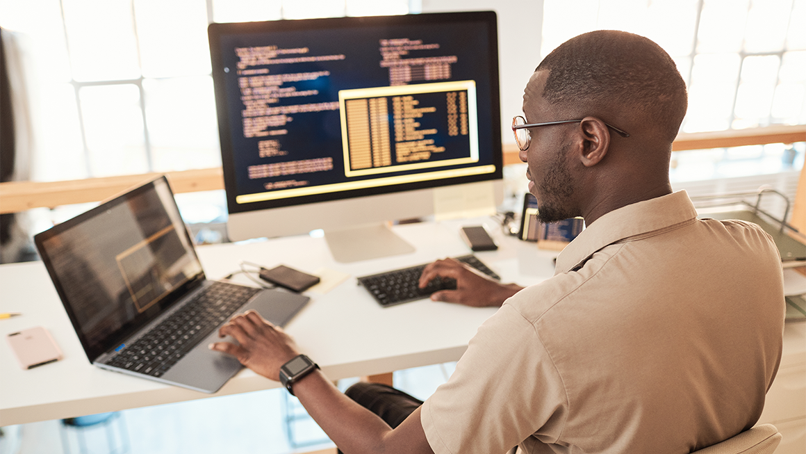 Dev ops engineer sitting at a desk working on code